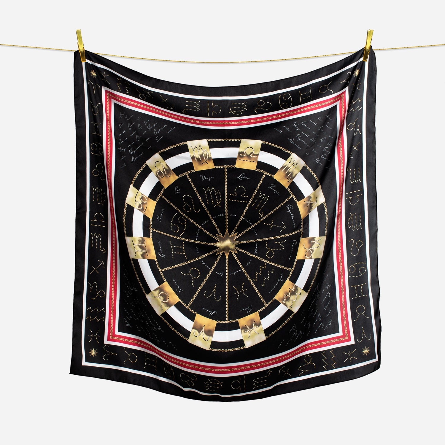 gold zodiac tags in circle chain design on black white and red scarf hanging on wire with gold pins